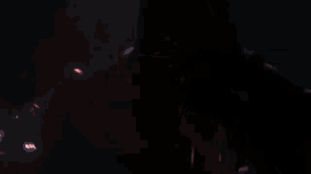 a close up of a person holding a red lightsaber in a dark room .