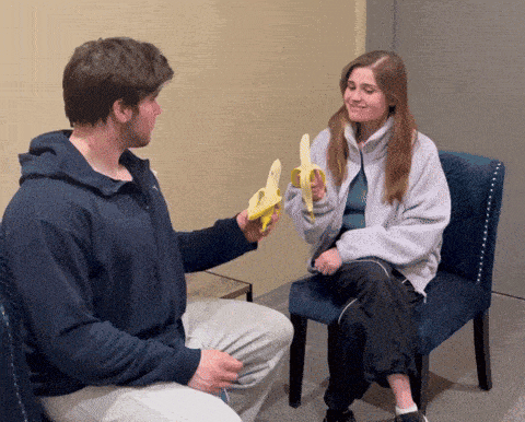 a man is giving a banana to a woman