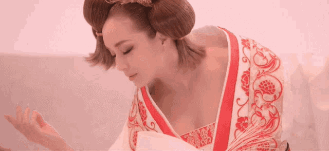 a woman in a red and white dress is sitting on a couch