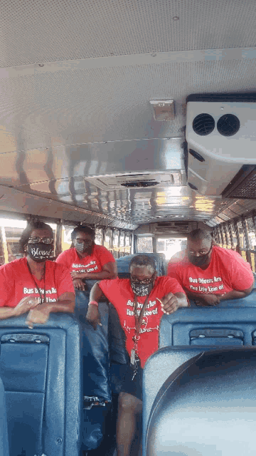 a group of people on a bus wearing masks and shirts that say bus drivers