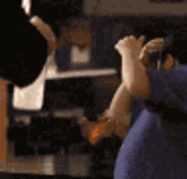 a man in a blue shirt is taking a picture of another man in a blue shirt .