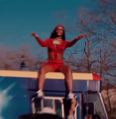 a woman in a red outfit is sitting on top of a bus
