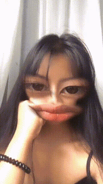 a woman with long hair is making a face with her hand