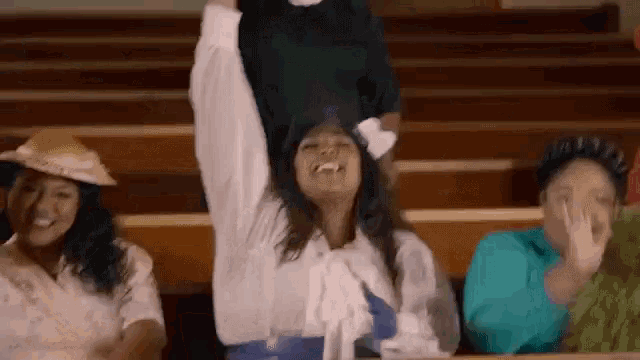 a group of women are sitting in a church with one woman holding a child in her arms .