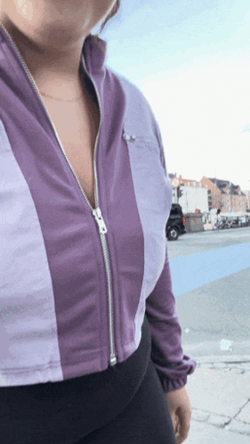 a woman wearing a purple jacket with a zipper