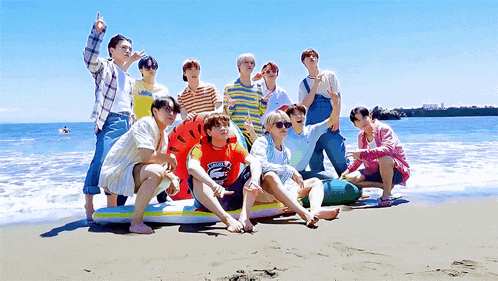 a group of young men posing for a picture on the beach