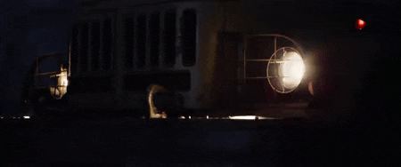 a bus is driving down a road at night with its lights on .