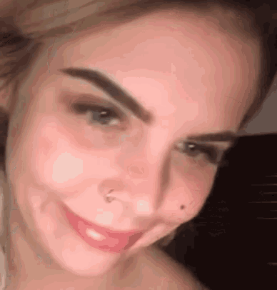 a close up of a woman 's face with a nose ring and a nose ring .