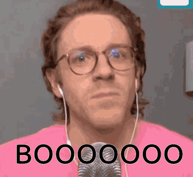 a man wearing glasses and ear buds says booooooo