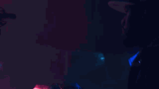 a blurry picture of a person in a dark room with blue lights behind them