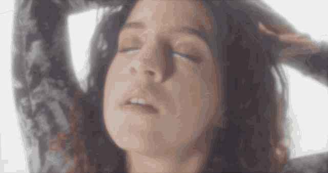 a woman with her eyes closed is wearing a black lace top