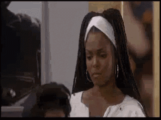a woman with dreadlocks and hoop earrings is wearing a headband .