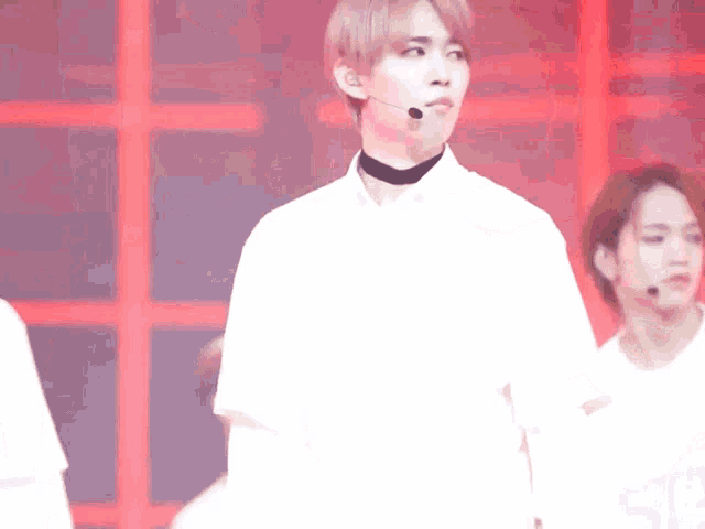 a man wearing a choker is standing next to another man wearing a microphone