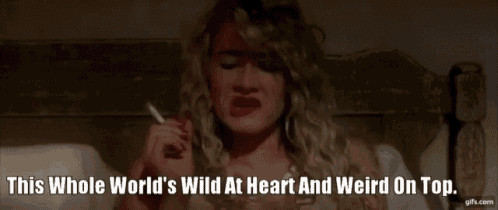 a woman is smoking a cigarette in bed with the words this whole world 's wild at heart and weird on top .