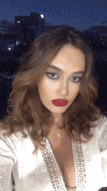 a woman with red lipstick and a cross necklace