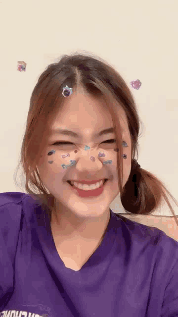 a girl wearing a purple shirt with the word choice on it is smiling