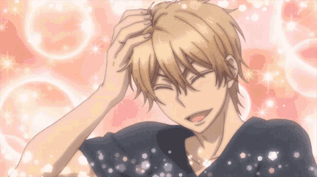 a man with blonde hair is smiling and holding his head
