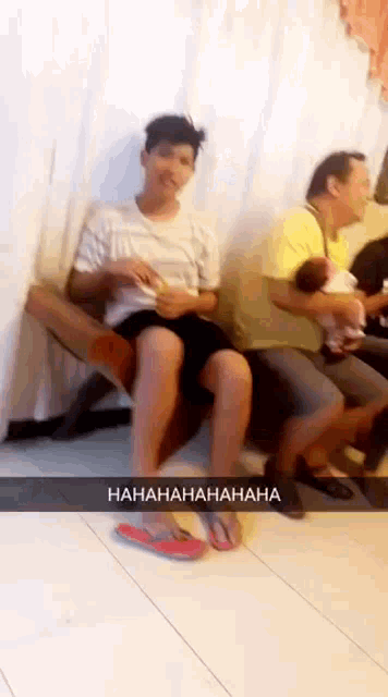a man is sitting on a chair with his legs crossed and a caption that says ' hahahahaha '
