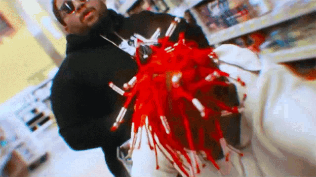 a man in a black hoodie is holding a person with blood dripping from their head