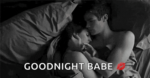 a man and a woman are laying in bed hugging each other and kissing .