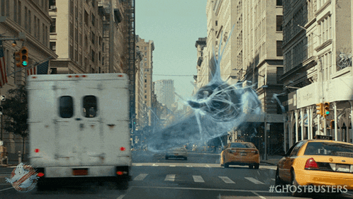 a white van is driving down a city street with a ghostbusters logo on the side
