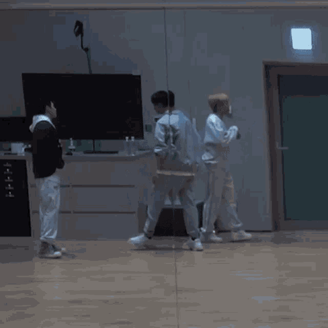 a group of young men are dancing in a dark room .