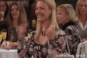 a woman is smiling while sitting at a table with other women