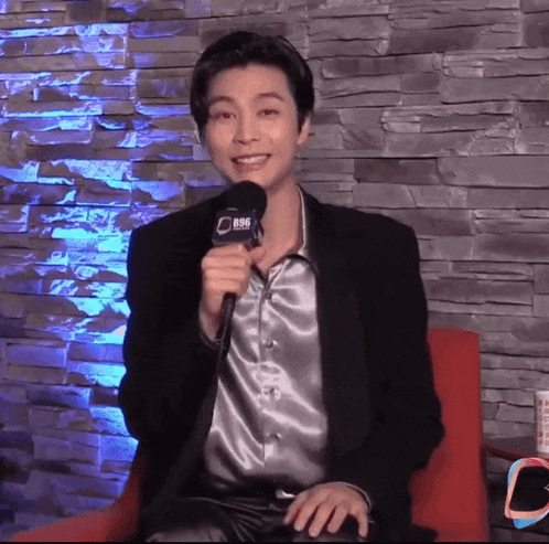 a man in a suit is holding a microphone that says 896