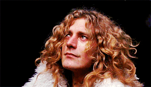 a close up of a man with long curly hair