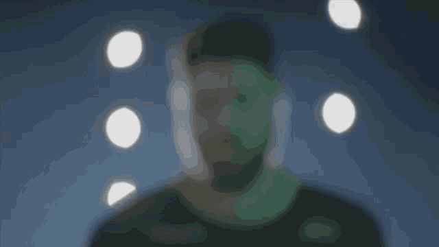 a blurry picture of a man 's face with circles coming out of his eyes .