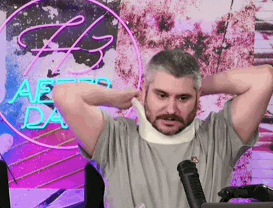 a man is wearing a neck brace while sitting in front of a neon sign .