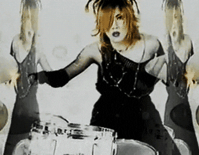 a woman in a black dress is playing drums in a black and white photo