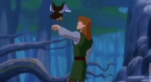 a man in a green shirt is holding a bird in his hand .