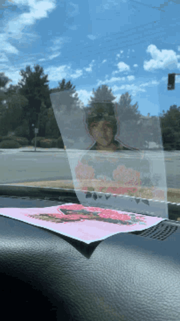 a picture of a woman with flowers on her head is on the dashboard of a vehicle