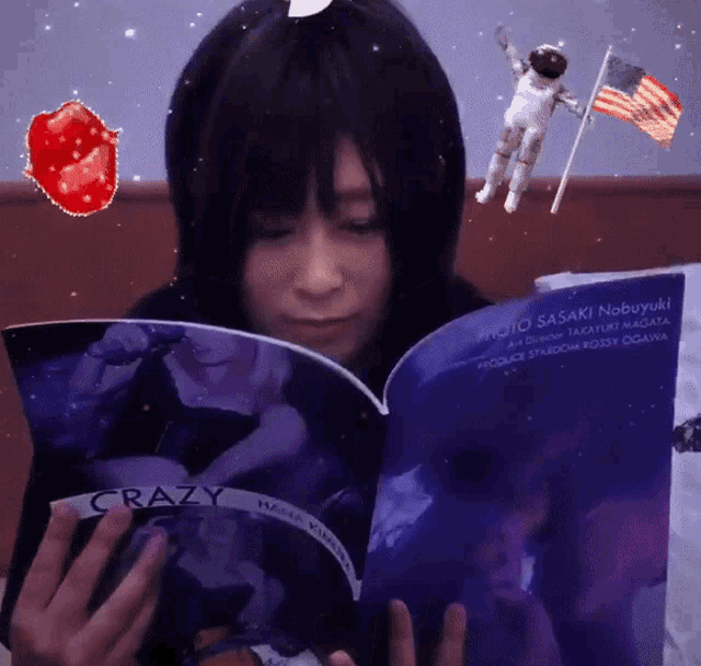 a woman is reading a book called crazy with an astronaut in the background
