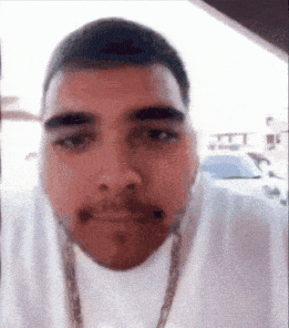 a man with a beard is wearing a chain around his neck .