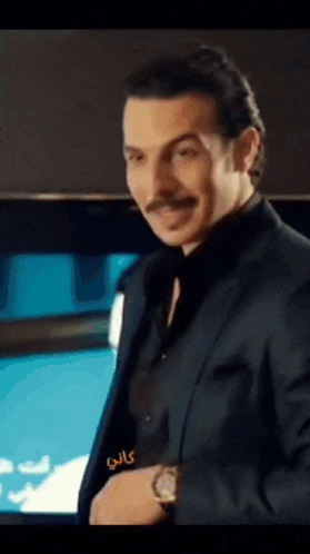 a man with a mustache is wearing a suit and watch
