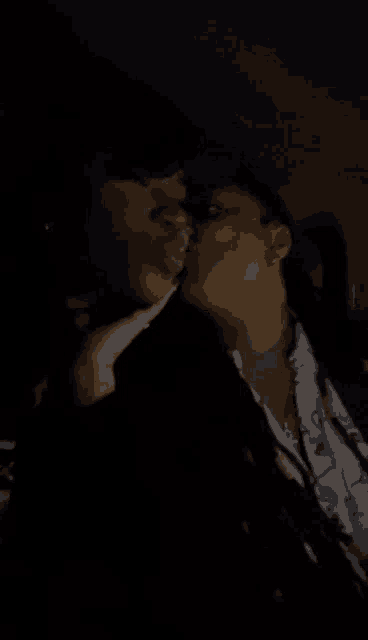 a couple kissing in a dark room with their tongues out