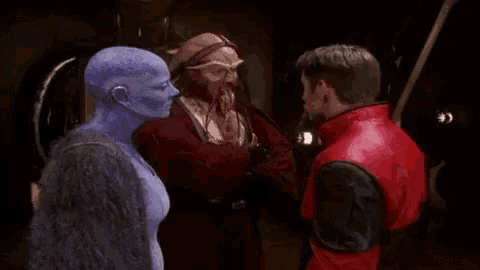 a man in a red jacket and a woman with blue skin are talking to each other