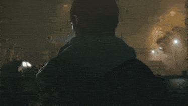 a close up of a man 's face with a beard in a dark room