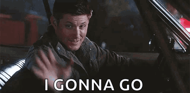 a man is sitting in a car waving his hand and saying i gonna go .