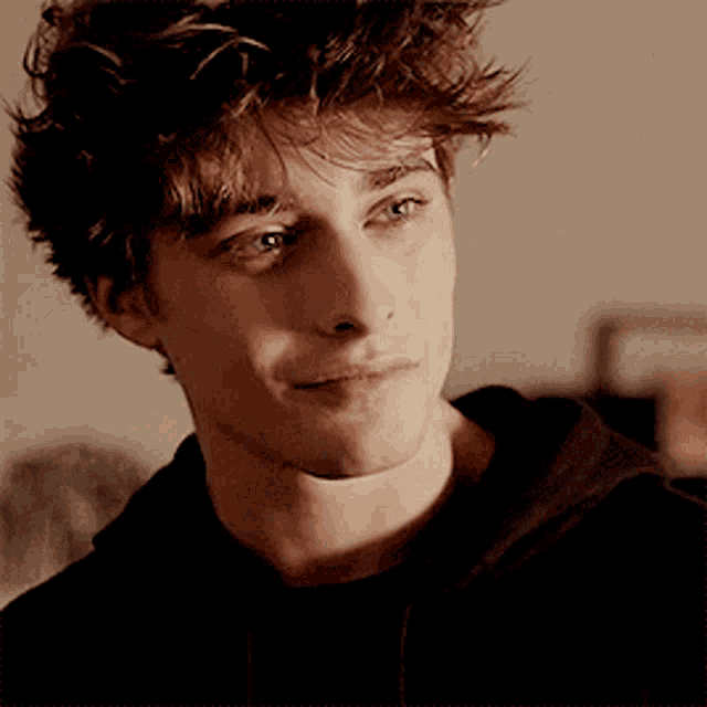 a close up of a young man with curly hair