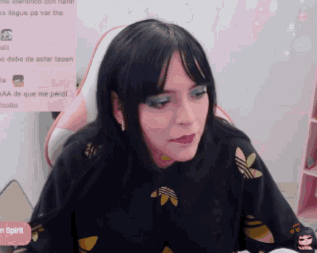 a woman is sitting in front of a pink screen that says " en spirit "