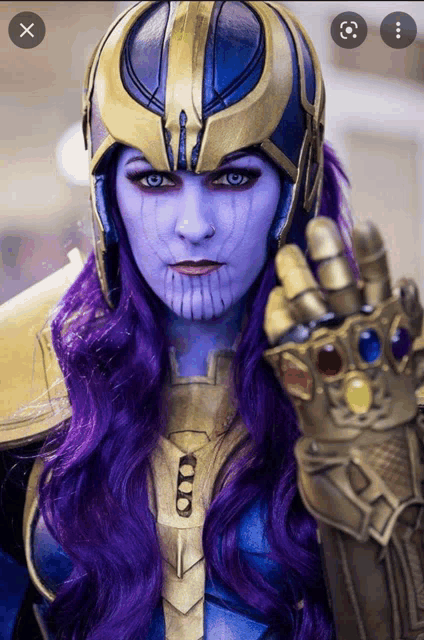 a woman in a thanos costume with purple hair and blue eyes