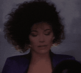 a close up of a woman 's face with a purple jacket on