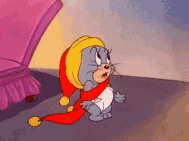 a cartoon cat wearing a hat and scarf is standing next to a bed .