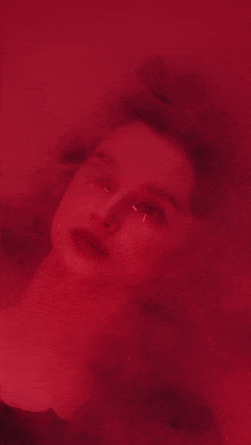 a close up of a woman 's face in a red room