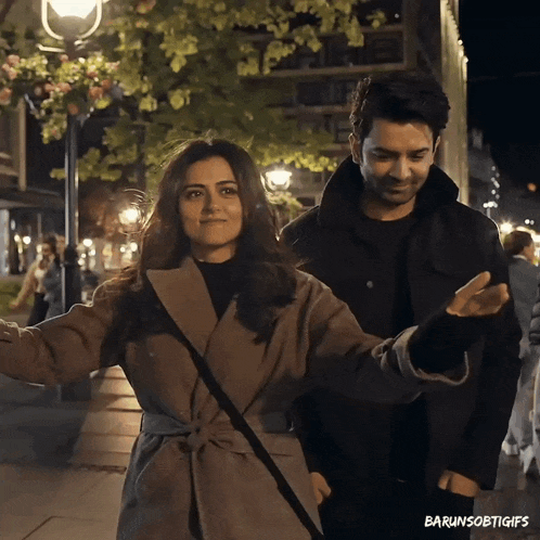 a man and a woman are walking down a street with the caption barunsoetgifs on the bottom