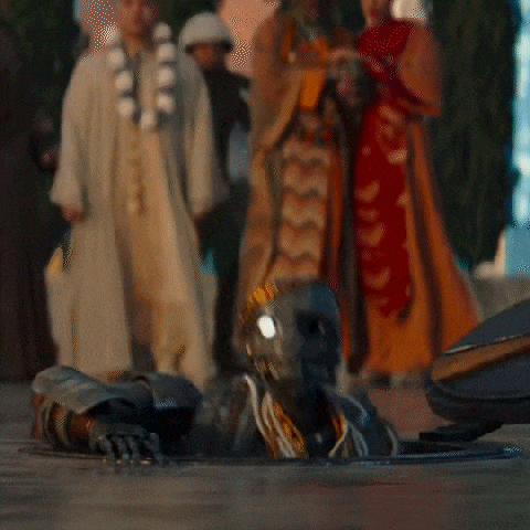 a robot is crawling out of a hole in the ground in a crowded area .
