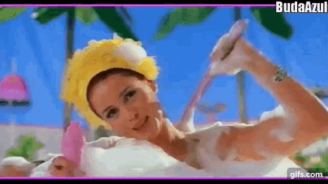 a woman is taking a bath in a bathtub and holding a hose .